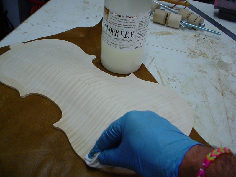 Preparing for the scribing of the purfling. A layer of pore filler on the edge.