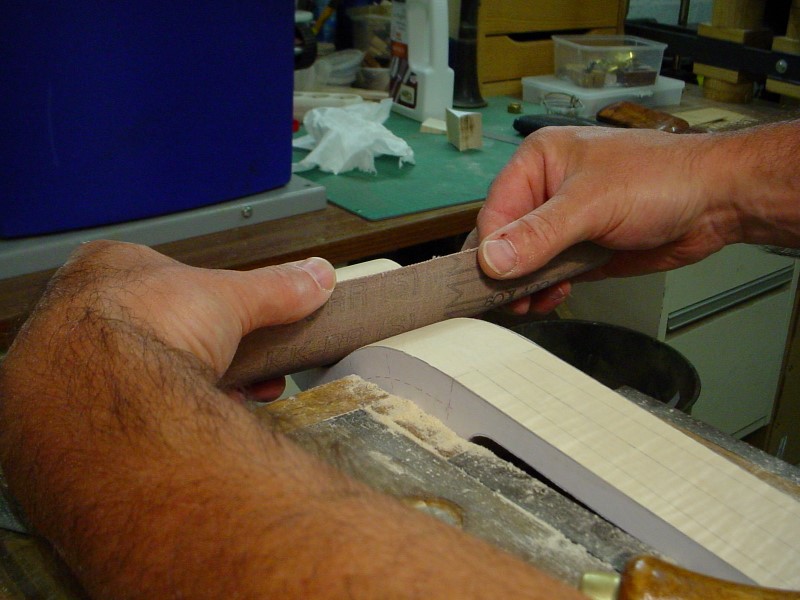 Smoothing the scroll with an heavy piece of sanding belt.