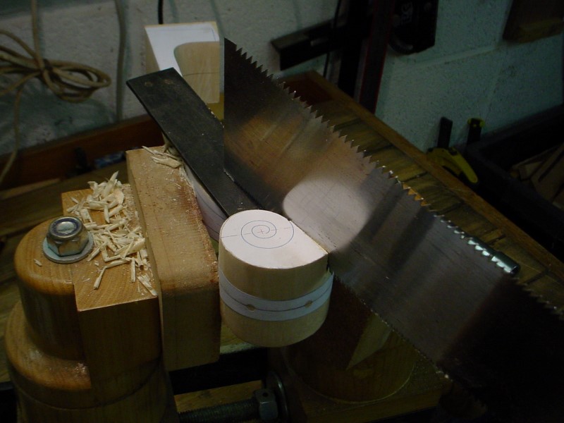 I start the carving of the scroll by different cuts with the hand saw, turning around the center button.