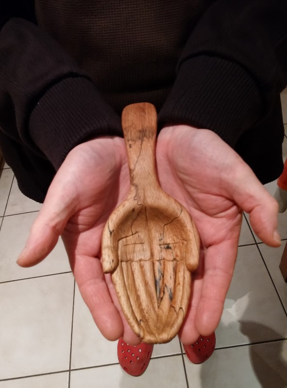 Open Hands carved spoon.